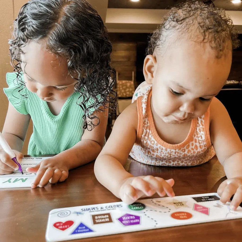 A toddler and a preschooler actively using the Preschool Bundle boards - Kids Fundamentals